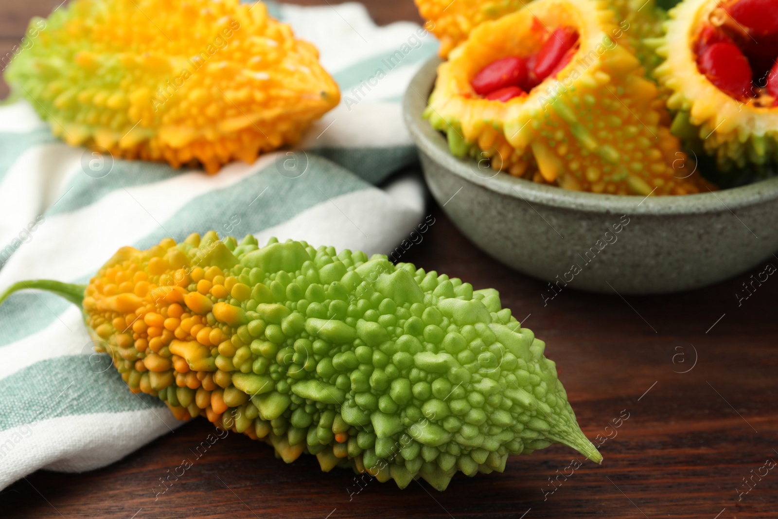 Photo of Many fresh bitter melons on wooden table, closeup