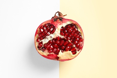 Photo of Half of ripe pomegranate on color background, top view