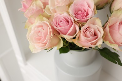 Photo of Beautiful rose flowers on shelf in room, above view and space for text. Interior design