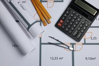 Photo of Construction drawings, pair of compasses, calculator and folding ruler on house plan, flat lay. Architect workspace