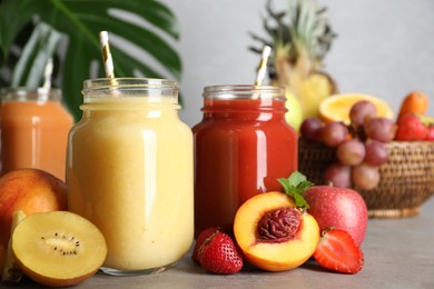 Photo of Delicious juices and fresh ingredients on grey table