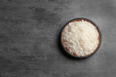 Photo of Boiled rice in bowl on grey background, top view with space for text