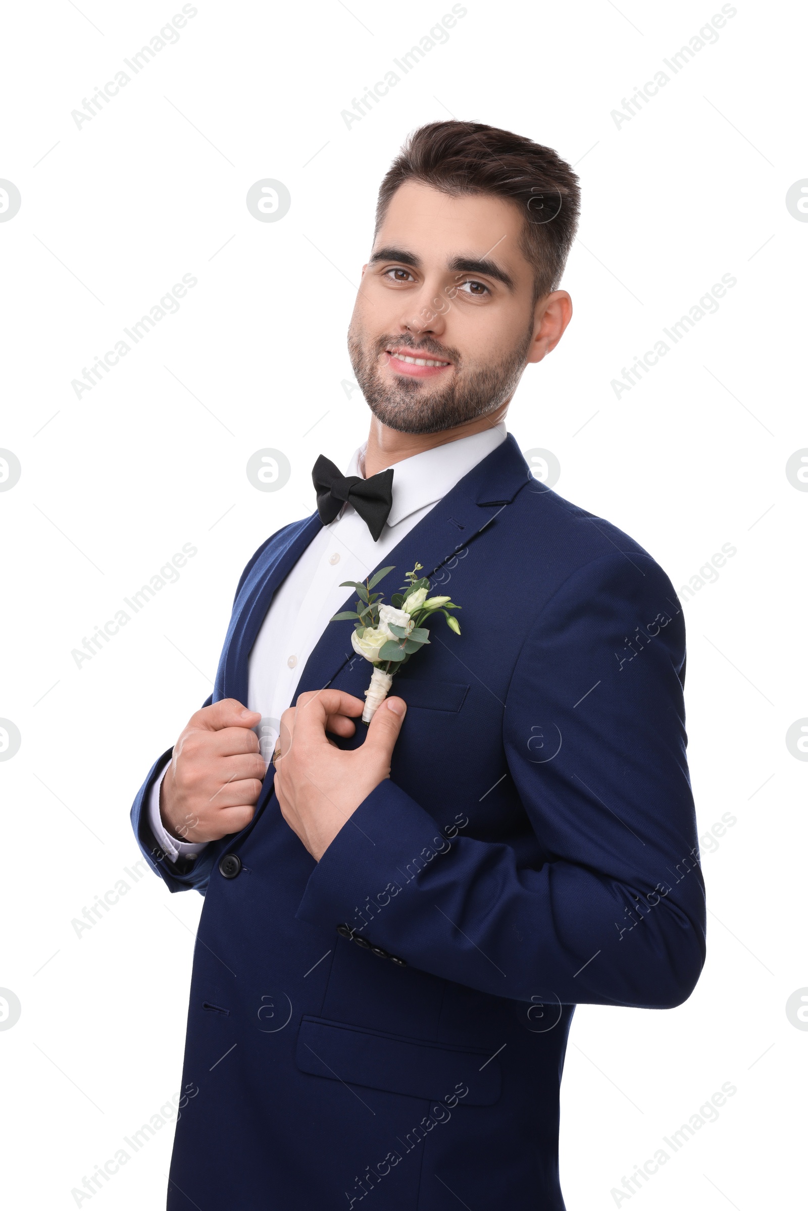 Photo of Handsome young groom with boutonniere on white background. Wedding accessory