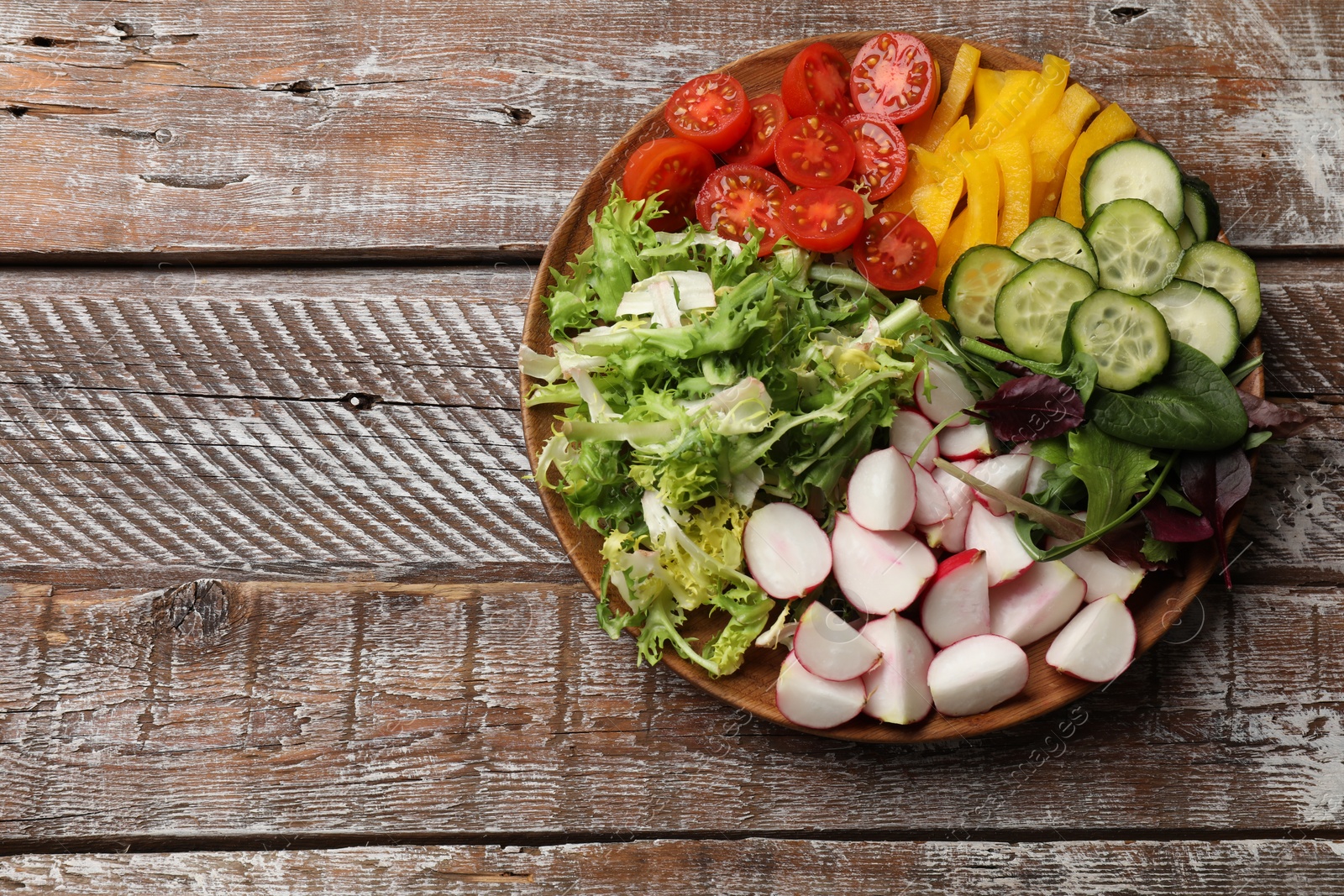 Photo of Vegetarian diet. Plate with tasty vegetables on wooden table, top view. Space for text