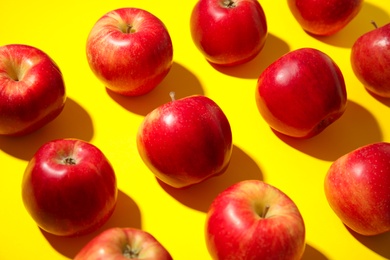 Fresh ripe red apples on yellow background