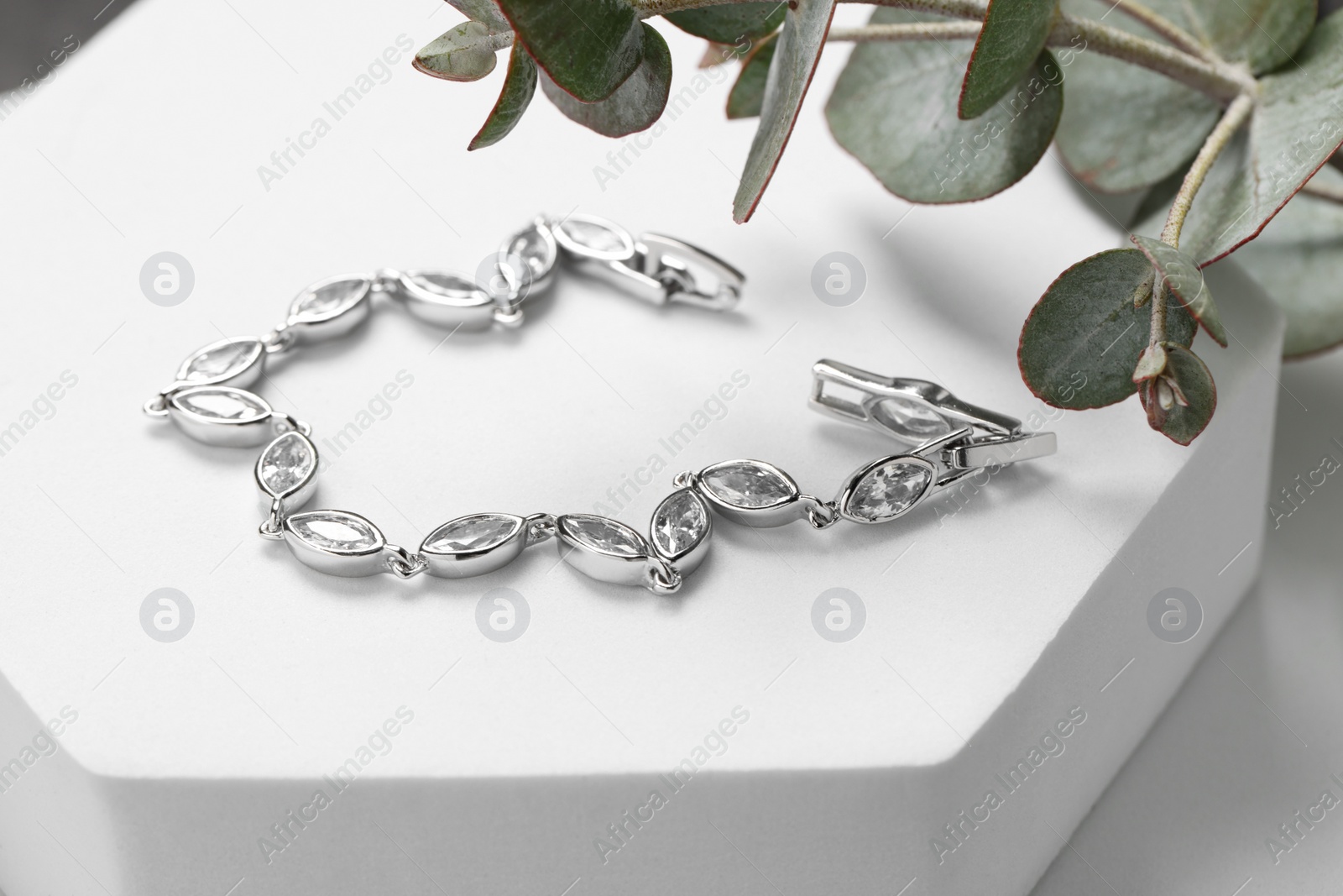 Photo of Beautiful bracelet with gemstones on white podium. Luxury jewelry