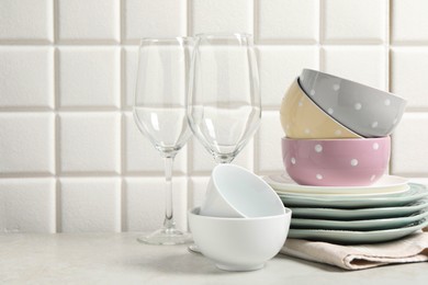 Photo of Beautiful ceramic dishware and glasses on light grey table, space for text