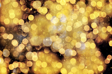 Image of Blurred view of gold lights on black background, bokeh effect