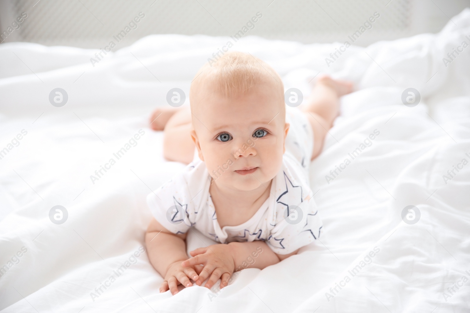 Photo of Cute little baby lying on bed at home