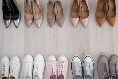 Collection of different shoes on floor, flat lay with space for text