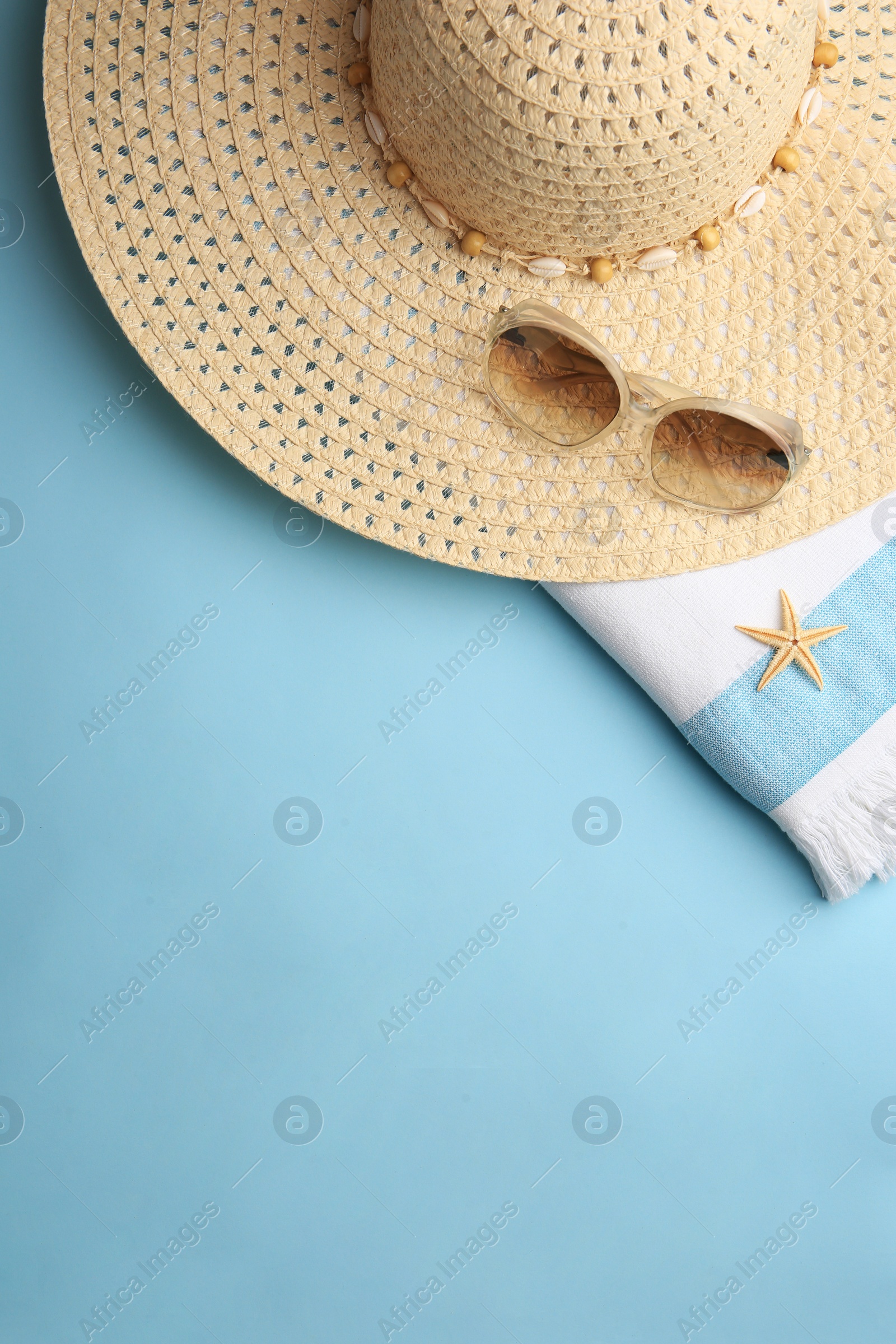 Photo of Flat lay composition with beach accessories on light blue background, space for text