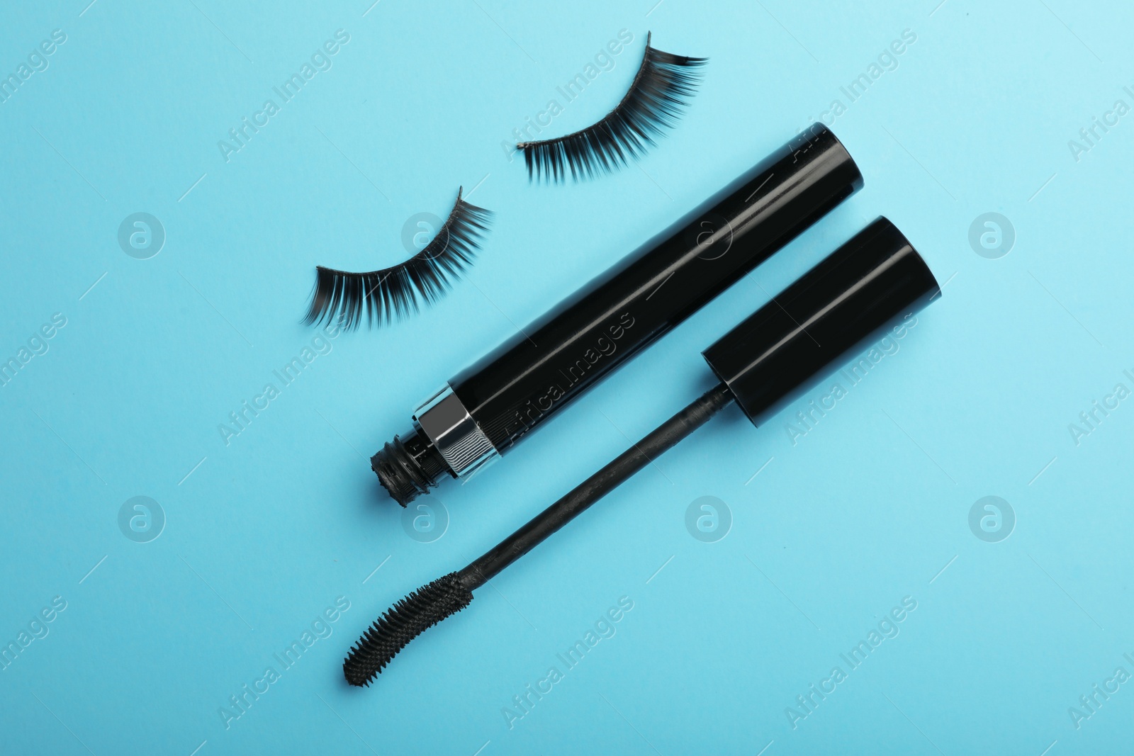 Photo of Flat lay composition of black mascara and false eyelashes on color background