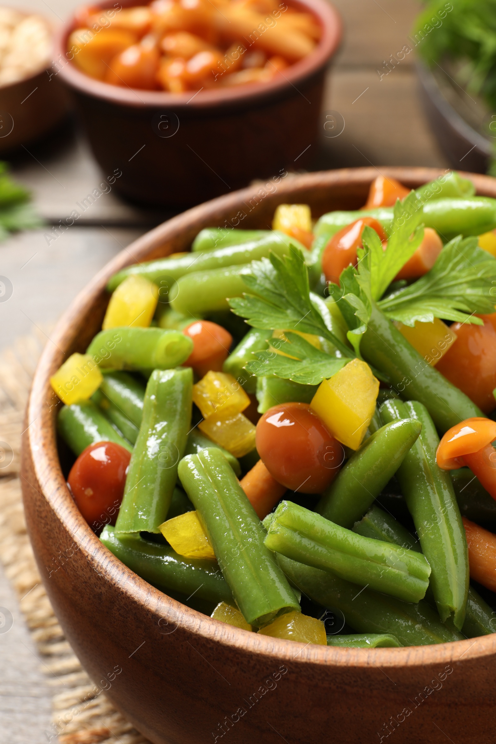 Photo of Bowl of tasty salad with green beans on table, closeup view