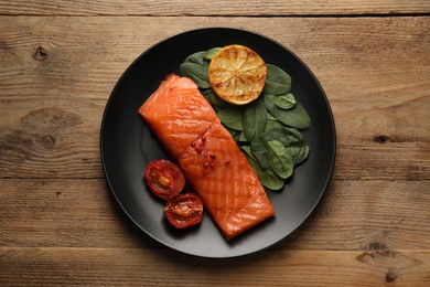 Photo of Tasty grilled salmon with tomatoes, lemon and basil on wooden table, top view