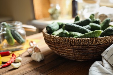 Photo of Fresh cucumbers and other ingredients on wooden table, closeup with space for text. Pickling vegetables