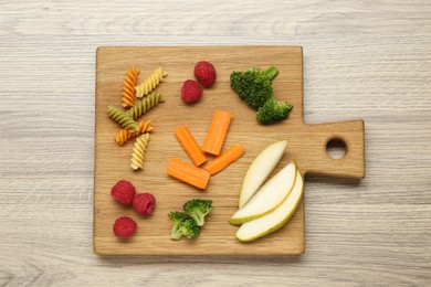 Photo of Board with different tasty finger foods for baby on wooden table, top view