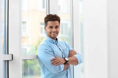 Photo of Portrait of handsome young man near window