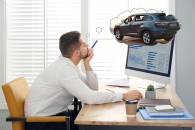 Image of Man dreaming about new car in office