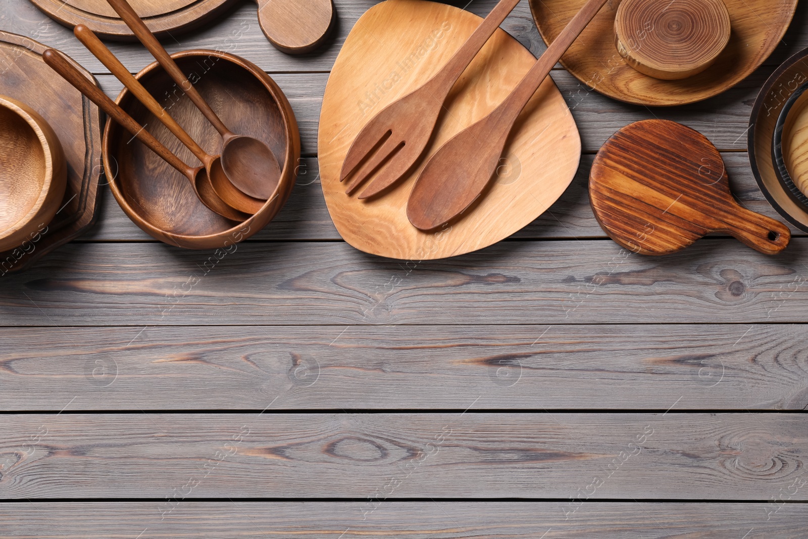 Photo of Set of wooden kitchenware on grey table, flat lay. Space for text