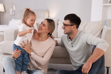 Photo of Family with little daughter spending time together at home