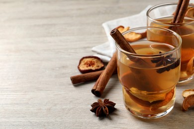 Delicious compote with dried apple slices, anise and cinnamon on white wooden table, space for text