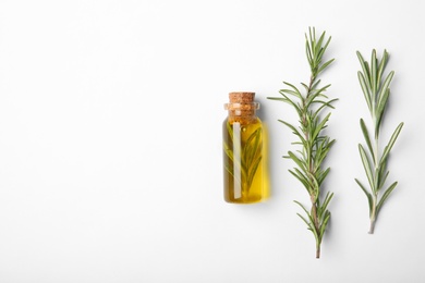 Composition with bottle of rosemary oil on white background, top view