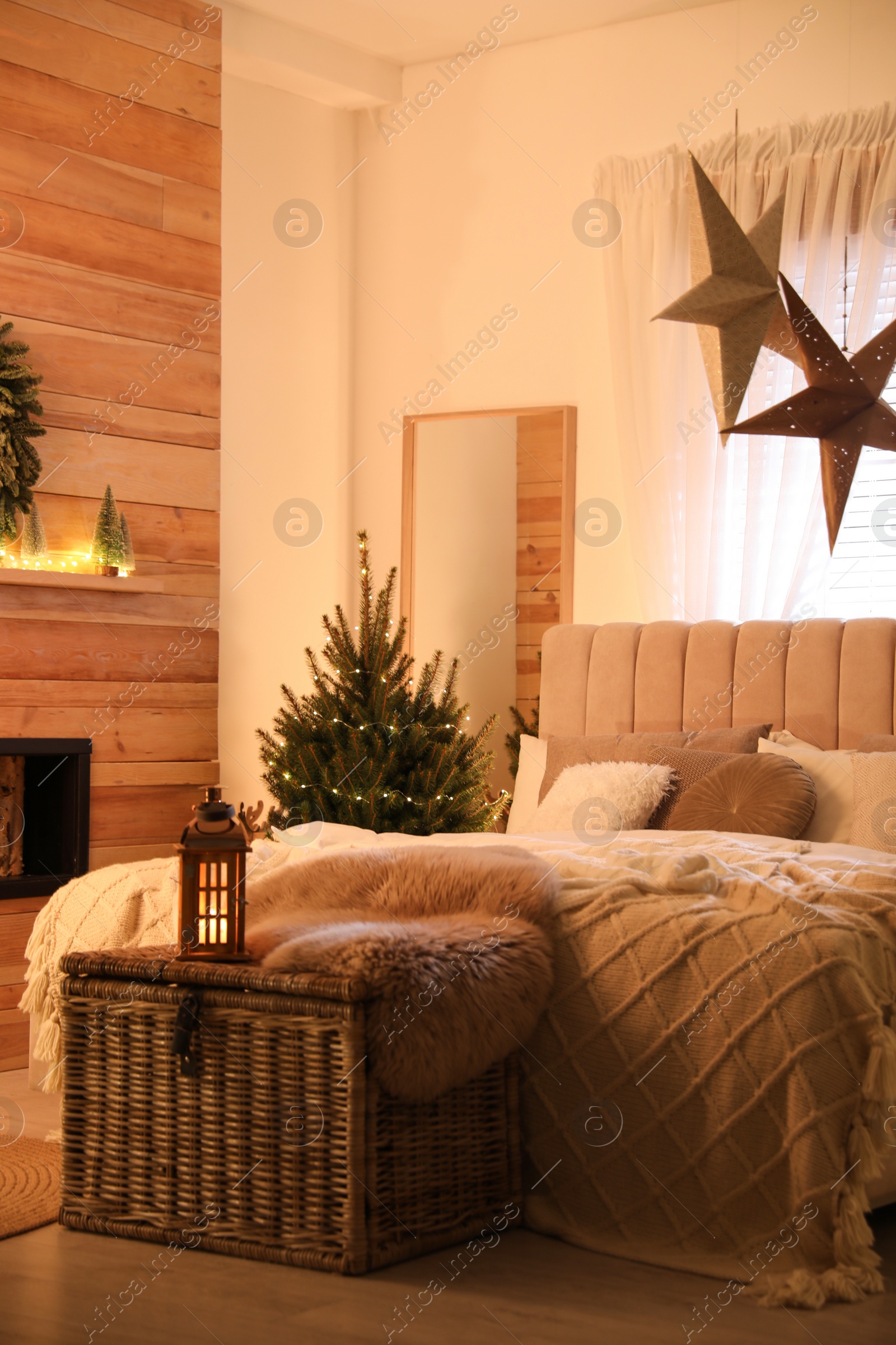 Photo of Beautiful decorated Christmas tree with fairy lights in bedroom interior