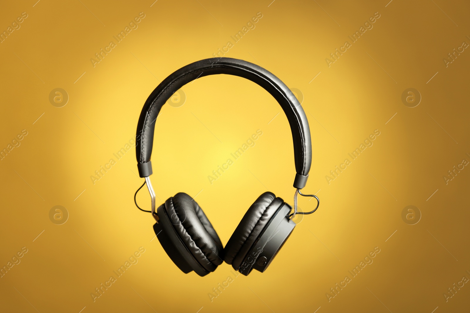 Photo of Stylish headphones with pads on color background