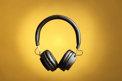 Photo of Stylish headphones with pads on color background