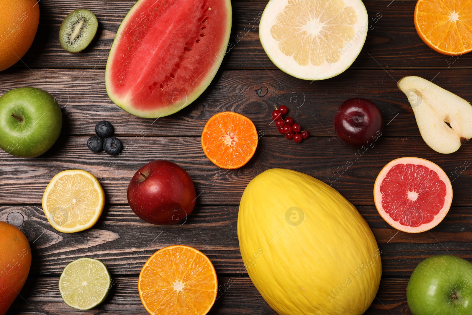 Photo of Different ripe fruits and berries on wooden table, flat lay