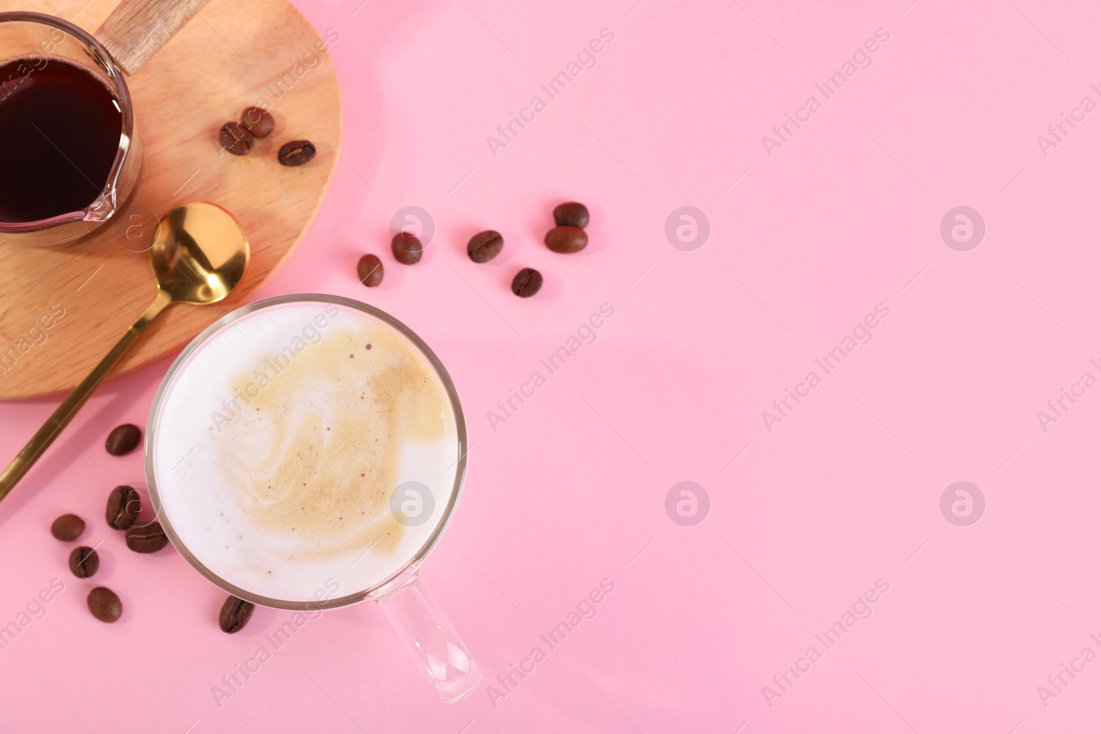 Photo of Cup of fresh coffee and beans on pink table, flat lay. Space for text