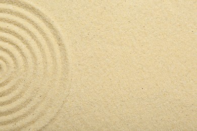 Photo of Zen rock garden. Circle pattern on beige sand, top view