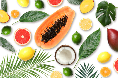 Image of Tropical layout with fresh exotic fruits and green leaves on white background, top view