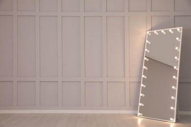 Photo of Modern mirror with light bulbs near molding wall in room, space for text