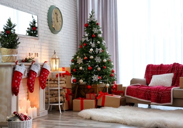 Stylish interior with beautiful Christmas tree and decorative fireplace