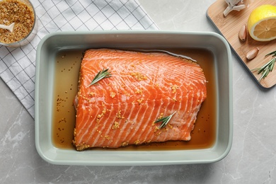 Photo of Marinated salmon fillet in dish on table, top view