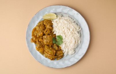 Photo of Delicious chicken curry with rice on beige background, top view