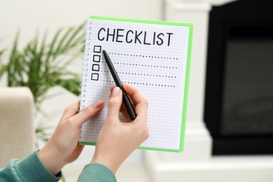 Photo of Woman filling Checklist with pen indoors, closeup