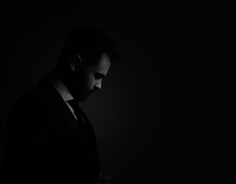 Image of Silhouette of man in darkness. Portrait on black background