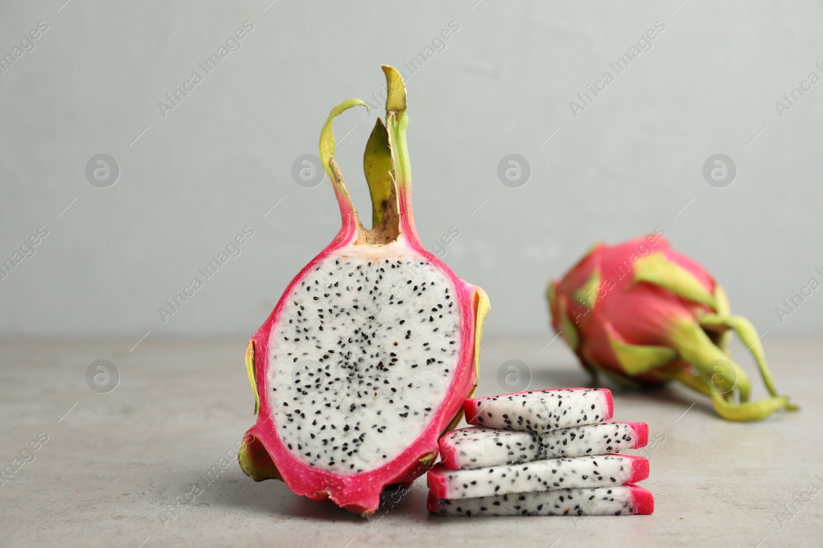 Photo of Delicious sliced dragon fruit (pitahaya) on grey table