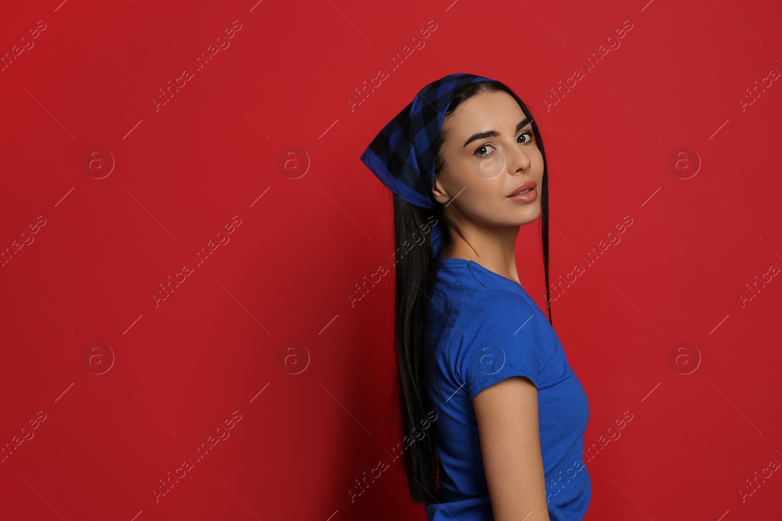 Photo of Young woman wearing stylish bandana on red background, space for text