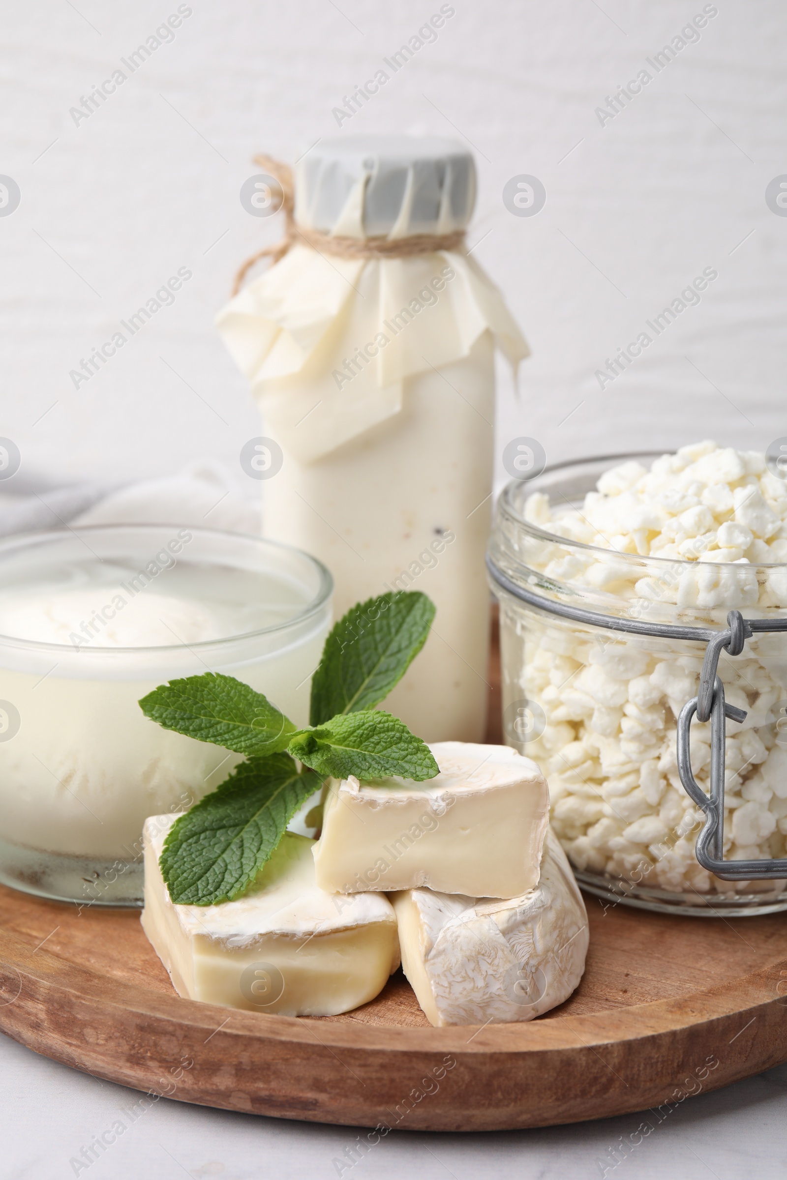 Photo of Different dairy products and mint on table