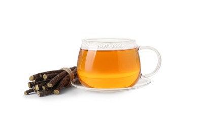 Aromatic licorice tea in cup and dried sticks of licorice root isolated on white