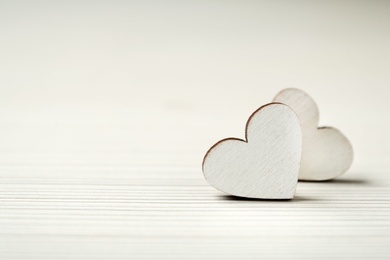 Photo of Decorative hearts on white wooden table, closeup with space for text. Valentine's day