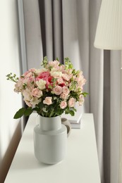 Beautiful bouquet of fresh flowers in vase on white table indoors