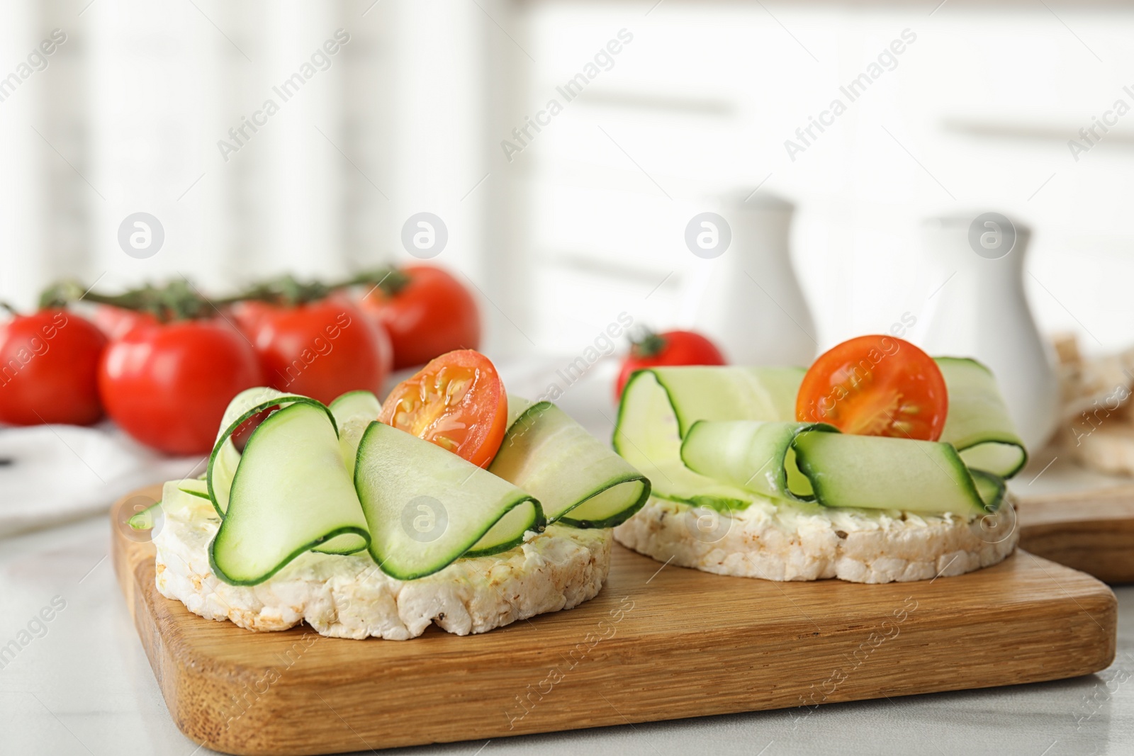 Photo of Puffed rice cakes with vegetables on white table