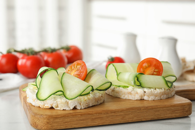 Photo of Puffed rice cakes with vegetables on white table