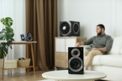 Photo of Man enjoying music with modern audio speaker system in room