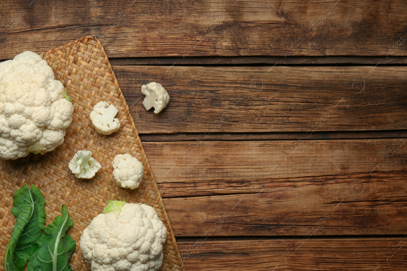Photo of Fresh cauliflower on wooden table, top view. Space for text