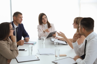 Office employees talking at table during meeting